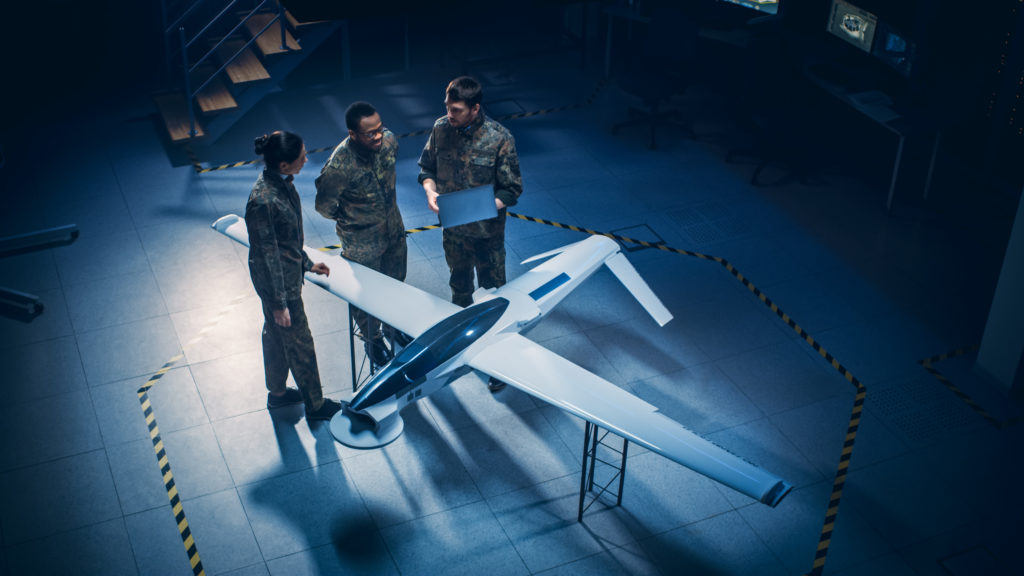 Inneos | Optics vs Copper: Debunking Myths and Understanding the Real Benefits Three military professionals standing around a model air plane