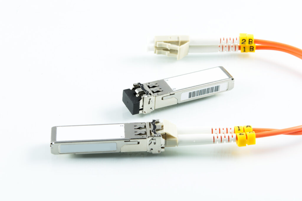 Inneos | What is an Optical Engine? Fiber cable plugged into a silver optical engine