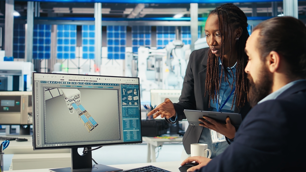 Inneos | Video Over Fiber Makes the Difference in Industrial Environments Two people sitting around a manufacturing monitor.
