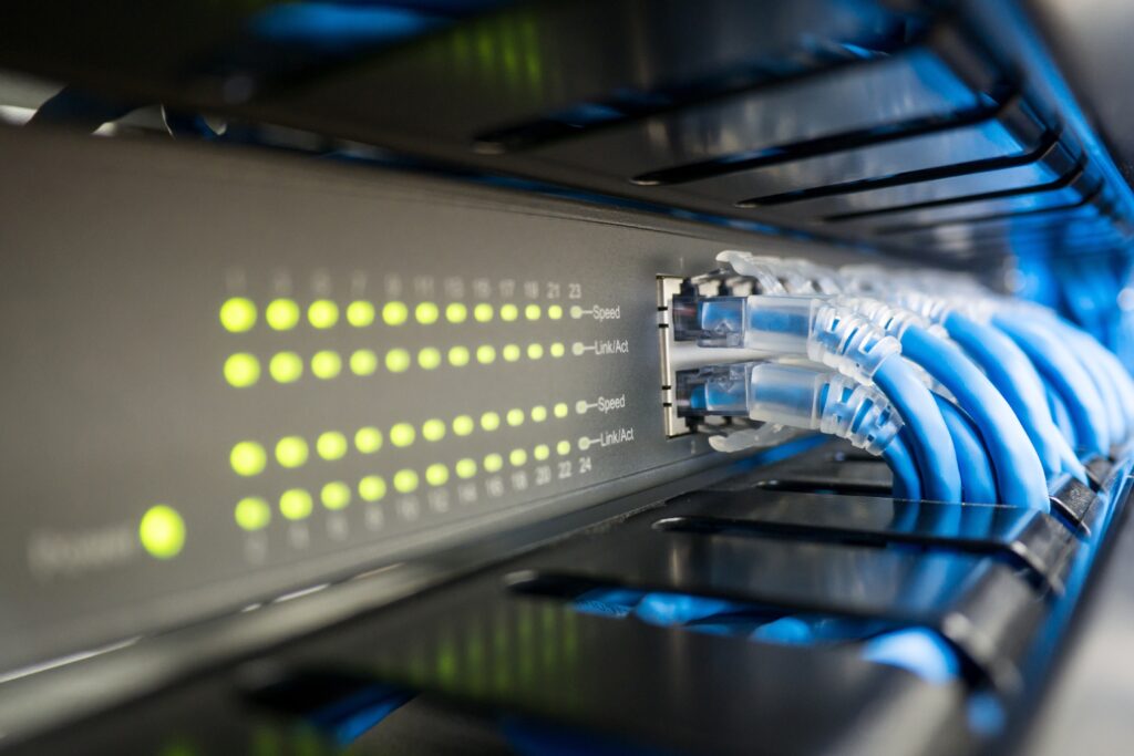 Inneos | Unleashing the Lightwaves: The Advantages of SWDM Optical Connectivity Ethernet cables connected to network box, demonstrating SWDM.